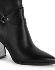 Detalle del material sintético en la bota negra con punta fina para dama con herraje decorativo y tacón medio 8cm
