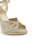 Vista a detalle de zapatilla para mujer con pulsera ajustable al tobillo y tacón delgado de 11cm color oro