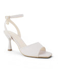 Vista diagonal de zapatilla beige de diseño descubierto para mujer con pulsera ajustable y tacón de 9cm