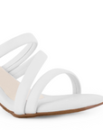 Vista a detalle de tiras delgadas cruzadas sobre el empeine en zapatilla blanca de diseño descubierto para mujer con tacón medio de 7cm