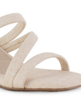 Vista a detalle de tiras delgadas cruzadas sobre el empeine en zapatilla beige de diseño descubierto para mujer con tacón medio de 7cm