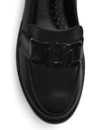 Vista del detalle de herraje metálico decorativo en mocasín negro tipo chunky con punta redonda para dama