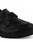 Detalle del material cabra sintético en el mocasín negro con punta redonda y herraje decorativo para dama