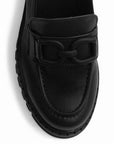 Vista del detalle en herraje decorativo del mocasín negro para dama con punta redonda y plataforma chunky tipo track