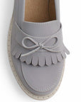 Vista del detalle en moño y flecos del mocasín gris para dama con tacón medio 8 cm
