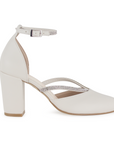 Vista lateral de zapatilla beige para mujer con pedrería en tiras y pulsera, punta cerrada y tacón de 8cm