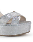 Detalle del material sintético en la zapatilla plateada para dama con tiras cruzadas plataforma y tacón alto 12cm