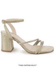 Vista lateral en la zapatilla dorada de fiesta para dama con tiras delgadas, pulsera ajustable al tobillo y tacón medio 7cm