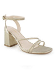 Vista diagonal de la zapatilla dorada para fiesta con tacón medio 7cm, pulsera ajustable al tobillo y tiras delgadas para dama