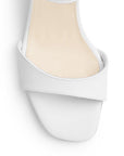 Vista de material cabra sintético en zapatilla blanca para mujer con tira frontal pulsera ajustable y tacón grueso de 7cm
