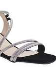 Vista a detalle de zapatilla negra para mujer con tiras brillantes y tacón bajo de 6cm