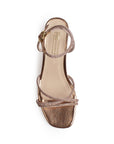 Vista superior de zapatilla oro rosa de diseño descubierto para mujer con tiras cruzadas de pedrería y pulsera al tobillo ajustable