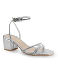 Vista diagonal de zapatilla plateada de diseño descubierto para mujer con tiras de pedrería pulsera al tobillo y tacón bajo de 6cm
