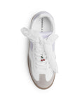 Vista superior de tenis blanco con morado de punta redonda para mujer con adorno colgante en las agujetas