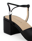 Vista a detalle de correa ajustable en zapatilla negra para mujer con tacón bajo de 5cm