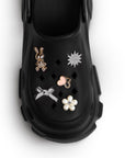 Vista del detalle en charms decorativos de la sandalia negra tipo clog para dama
