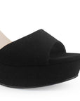 Vista a detalle de zapatilla negra para mujer con diseño abierto pulsera ajustable y tacón de 10cm