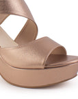 Vista a detalle de zapatilla oro rosado para mujer de diseño abierto con pulsera ajustable al tobillo y tacón medio de 10cm
