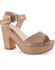 Vista diagonal de zapatilla para mujer con tacón ancho de 10cm y pulsera ajustable con hebilla en color oro rosado