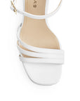 Vista de material cabra sintético en zapatilla blanca para mujer con tiras cruzadas y tacón alto de 11cm