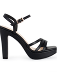 Vista lateral de zapatilla negra para mujer con tiras cruzadas y tacón alto de 11cm