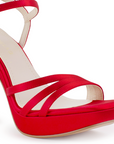 Vista a detalle de zapatilla roja para mujer con tiras cruzadas al frente y pulsera ajustable