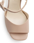 Vista de material cabra sintético en zapatilla nude para mujer con pulsera al tobillo hebilla forrada y tacón alto de 11cm