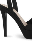 Vista trasera del tacón alto 12cm en zapatilla negra con plataforma, pulsera ajustable al tobillo punta abierta y moño para dama