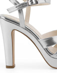 Vista trasera de tacón alto de 12cm en zapatilla plateada para mujer con pulsera ajustable y tiras cruzadas