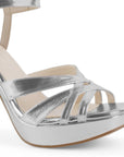 Vista a detalle de tiras entrelazadas en zapatilla plateada para mujer con plataforma frontal tacón alto de 12cm y pulsera ajustable