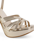 Vista a detalle de tiras entrelazadas en zapatilla dorada para mujer con plataforma frontal tacón alto de 12cm y pulsera ajustable