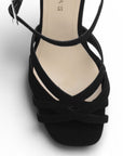 Vista de material buck en zapatilla de diseño descubierto para mujer con tiras cruzadas pulsera ajustable y tacón alto de 12cm en color negro