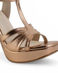 Vista a detalle de zapatilla oro rosa de diseño descubierto para mujer con pulsera ajustable y tacón de 12cm