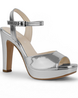 Vista diagonal de la zapatilla plateada con plataforma, punta abierta pulsera ajustable al tobillo y tacón alto 12cm para dama