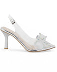 Vista lateral de zapatillas plateadas transparentes para mujer de diseño destalonado con correa ajustable punta fina moño de pedrería y tacón de 9cm