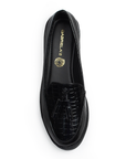 Vista superior del mocasín negro de material sintético con relieve, borlas decorativas para dama y suela de piso