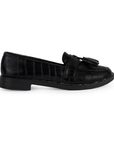 Vista lateral de mocasín negro de piso para mujer con borlas decorativas en empeine y punta redonda