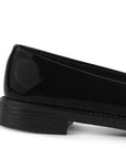 Vista trasera de la suela de piso en mocasín negro de charol con moño decorativo para dama