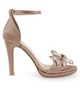 Vista lateral de zapatilla maquillaje para mujer con moño brillante y tacón delgado medio de 10cm