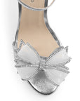 Vista de material sintético en zapatilla plata para mujer con pedreria en moño frontal y tacón delgado de 10cm