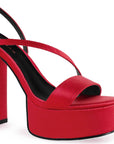 Vista a detalle de plataforma al frente con tiras delgadas cruzadas en zapatilla roja de tacón alto 14cm