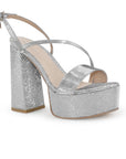 Vista diagonal de zapatilla plateada para mujer con tiras delgadas cruzadas y tacón alto grueso de 14cm