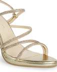 Vista a detalle de zapatilla oro para mujer con tiras de pedrería y tacón medio de 10cm