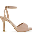Vista lateral de zapatilla nude para mujer con pulsera al tobillo y tacón delgado de 10cm de diseño descubierto
