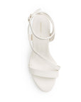 Vista superior de zapatillas beige con tiras cruzadas y pulsera ajustable al tobillo para mujer