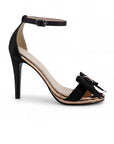 Vista lateral de zapatilla negra para mujer con pulsera ajustable y moño al frente de tacón delgado medio de 10cm