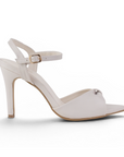 Vista lateral de zapatillas beige para mujer con tacón delgado de 9cm y pulsera ajustable al tobillo de diseño descubierto
