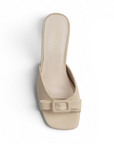 vista superior de zapatillas beige de tacón con punta descubierta y moño