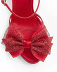 vista del detalle en el moño brillante de las zapatillas rojas para dama con tacón 11 cm y plataforma