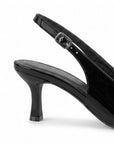 vista trasera del tacón medio 7cm en zapatillas negras de charol con talón descubierto